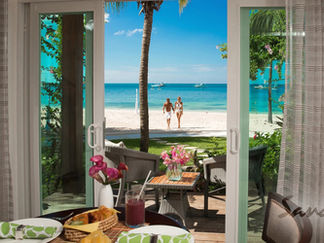 A couple enjoying their beachfront accommodations at Sandals Resorts, booked for them by Limin Professionals Luxury Concierge 