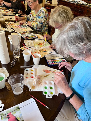 A vibrant group of artists collaborating and painting in a serene retreat setting.