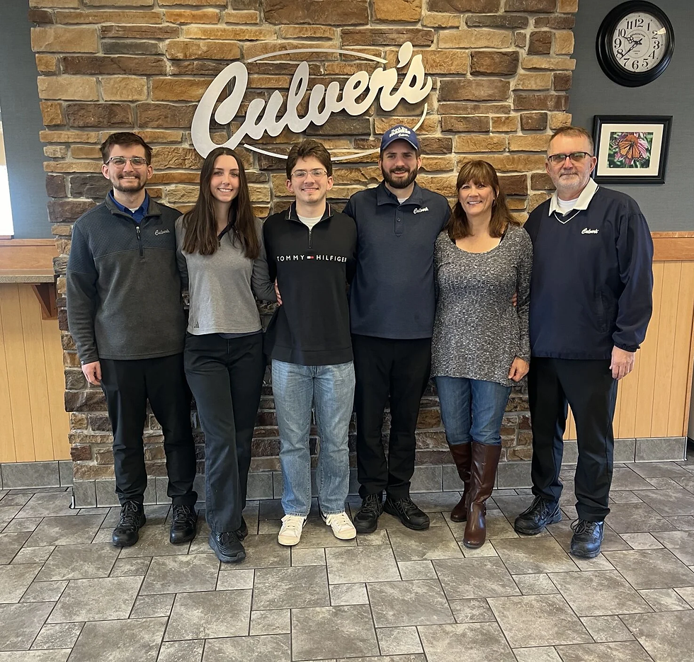 Employees stand in a casual setting, showcasing camaraderie in a restaurant environment.
