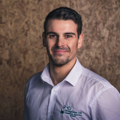 Business headshot of a young bearded male executive