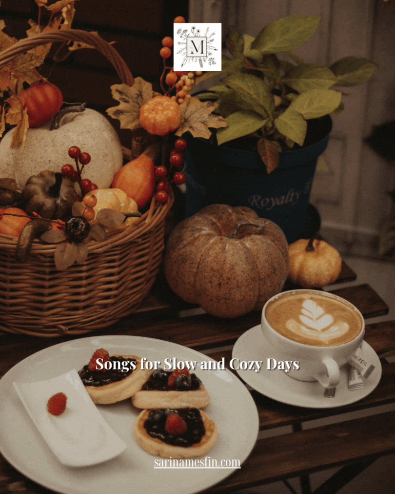 Autumn-themed scene with a wicker basket of pumpkins, pastries on a plate, and a latte. Text reads: "Songs for Slow and Cozy Days."