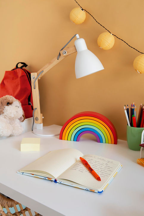 high-angle-children-s-desk-with-rainbow-notebook.jpg