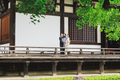 九品仏浄真寺のお堂の縁側に立つ七五三の男の子と両親