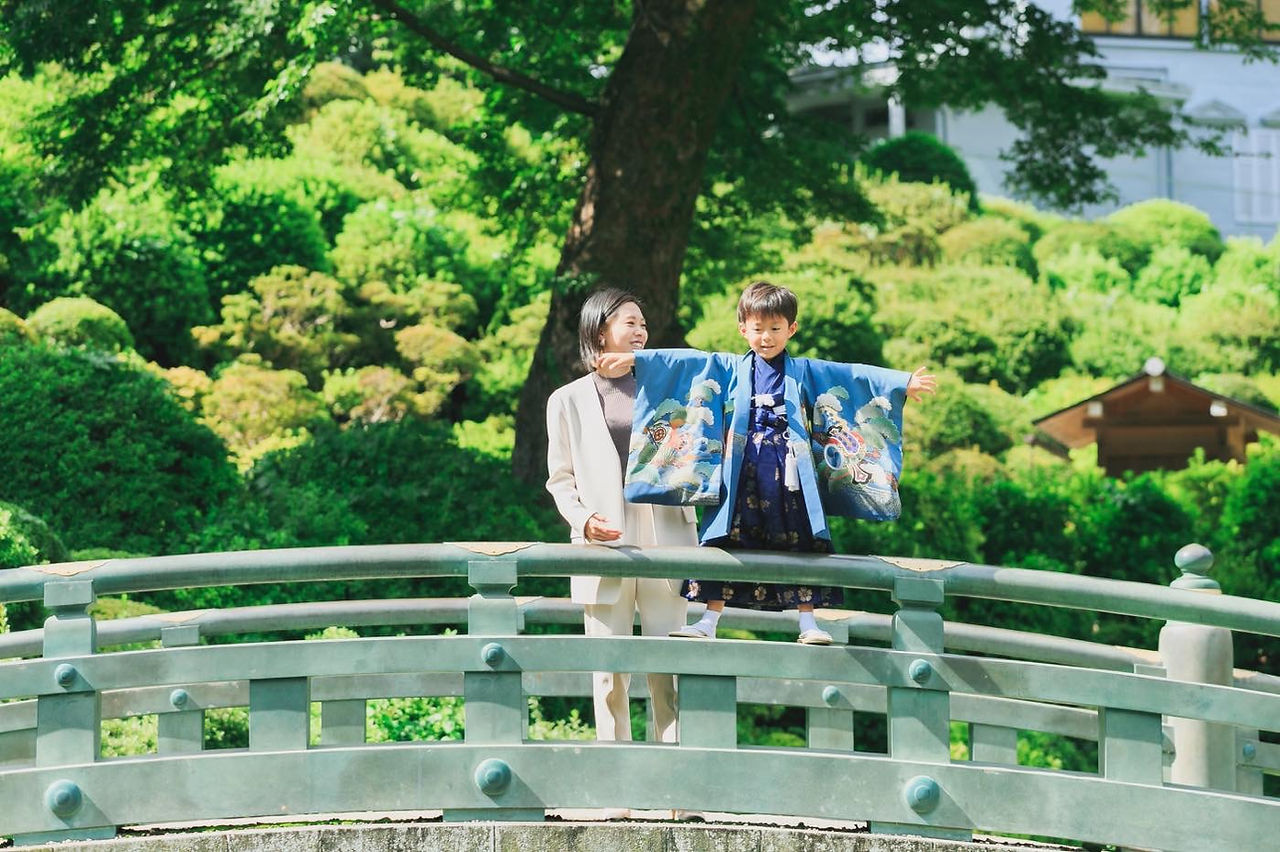元気いっぱいの兄弟が七五三の着物を着て笑顔で遊ぶ写真
