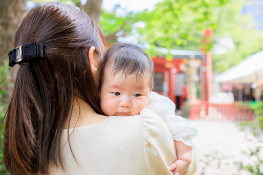 赤坂の日枝神社でのお宮参り撮影。赤ちゃんと家族が神社の境内で神聖な瞬間を迎える写真。