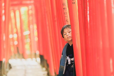 元気いっぱいの兄弟が七五三の着物を着て笑顔で遊ぶ写真