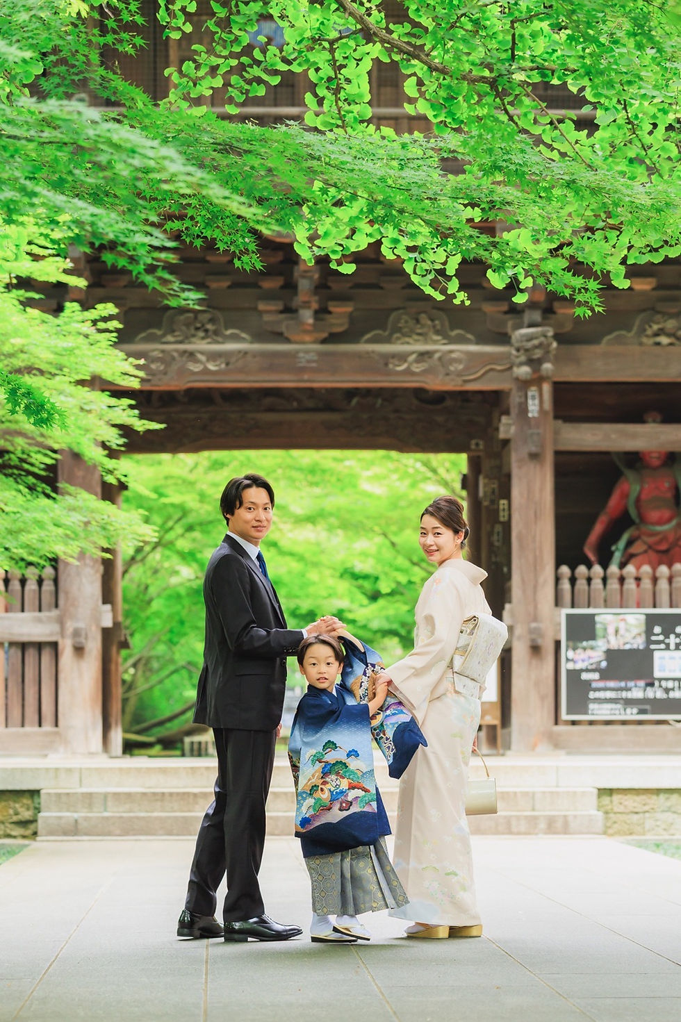九品仏浄真寺の門前で両親と並ぶ5歳の七五三の男の子
