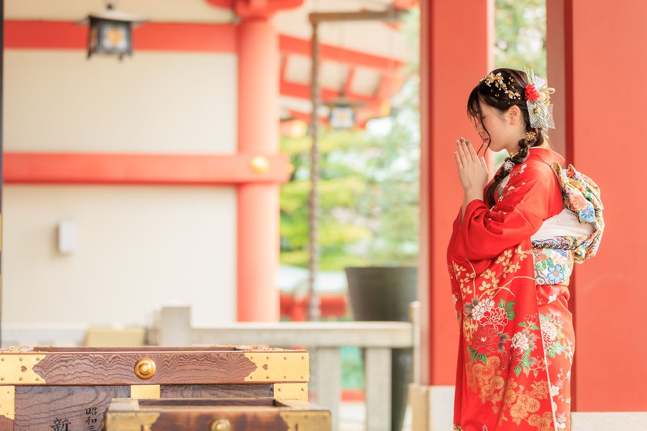 雨上がりの山王日枝神社で赤い振袖を着た新成人の前撮り写真