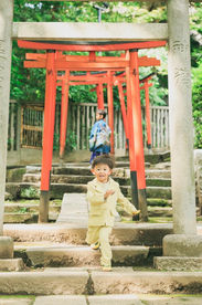 元気いっぱいの兄弟が七五三の着物を着て笑顔で遊ぶ写真