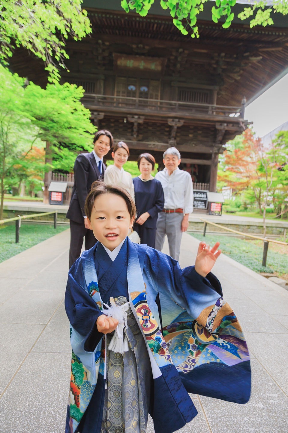九品仏浄真寺の門前で親族と記念撮影をする七五三の男の子