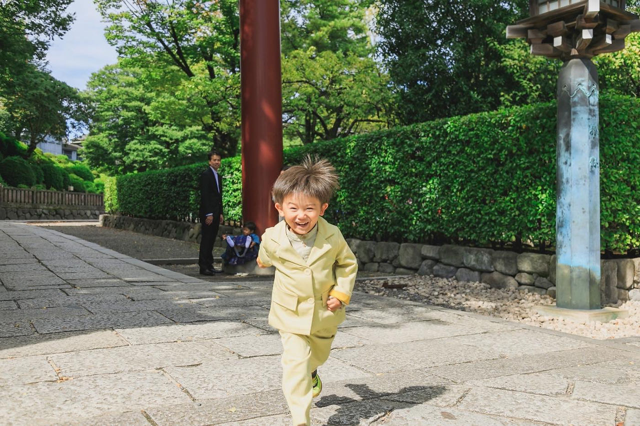 元気いっぱいの兄弟が七五三の着物を着て笑顔で遊ぶ写真