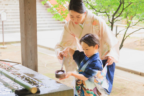 九品仏浄真寺の手水舎で母親と一緒に手を清める七五三の男の子