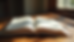 Eye-level view of an open Bible on a wooden table with soft natural light