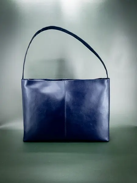 Lubay vegan laptop bag, Ieper Laptop model, in "violet almost blue" Leap, placed on a dark green background.