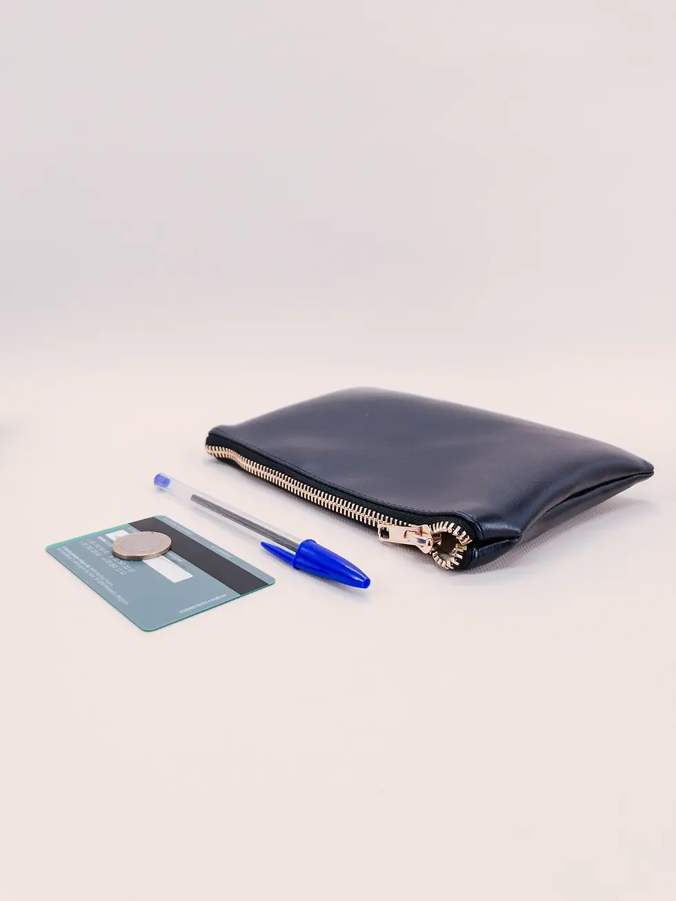 Miniature : Pochette vegan M de Lubay, en leap violet, vue du haut sur fond clair avec une carte de banque et un stylo..