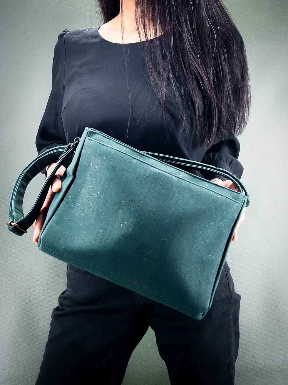 Thumbnail: Sac vegan Lubay, modèle Lint en liège vert sapin, tenu par une femme habillée en noir