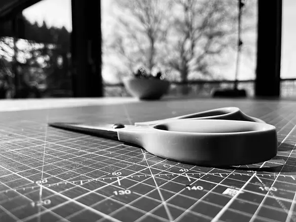 Close-up scissors on grid mat, Lubay studio-atelier — B&W