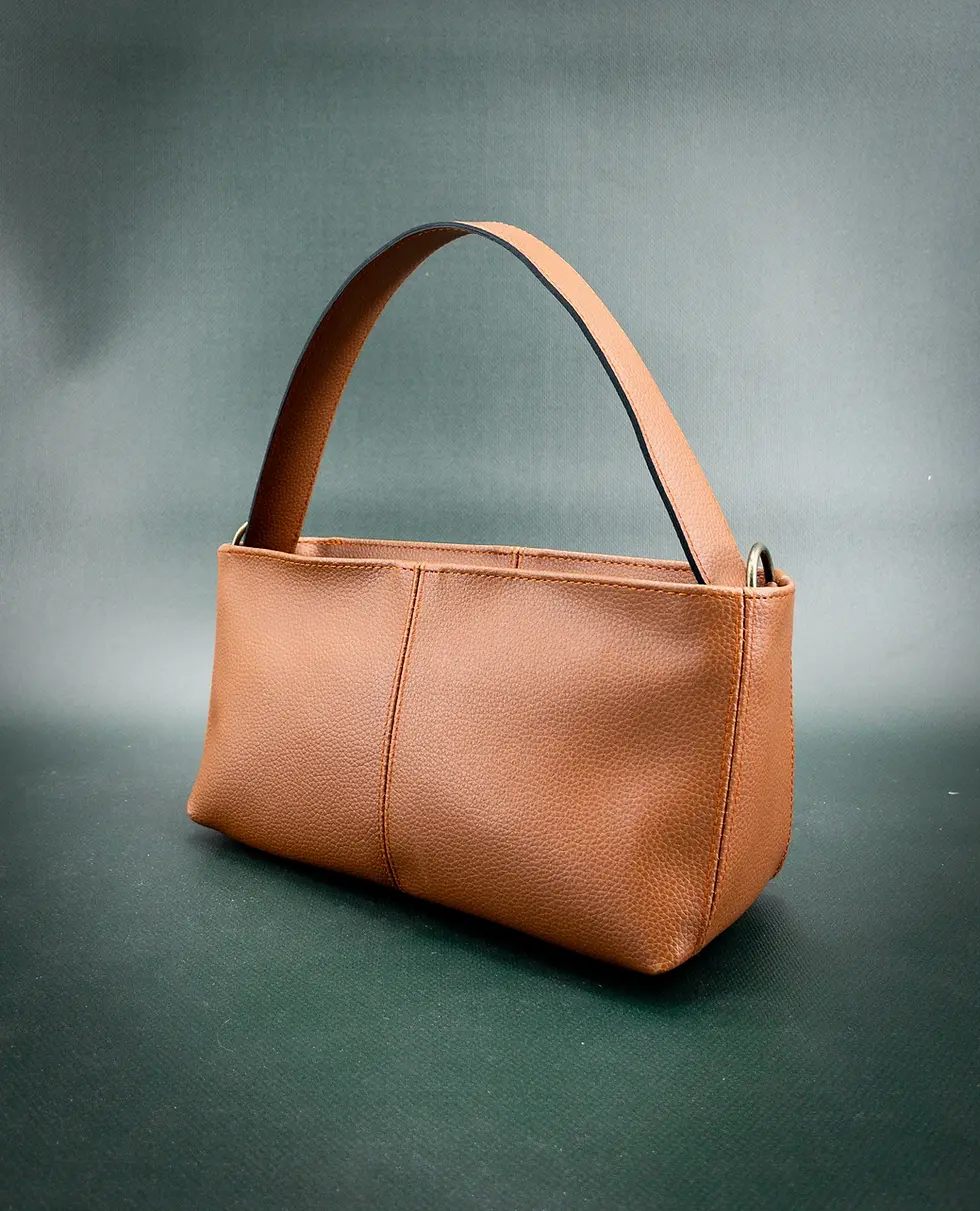 The vegan Lubay Ieper 25 bag in cognac, seen from a slight angle on a dark green background.