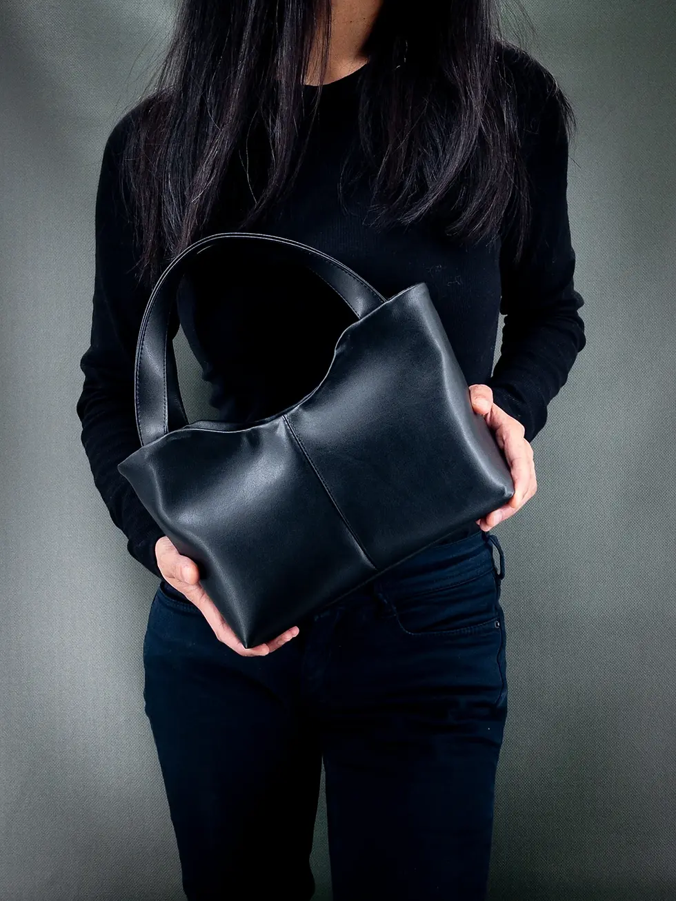 Lubay vegan bag, Scaldis M model in Leap black, held by a woman dressed in black.