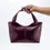 Thumbnail: Main de femme tenant le sac Lubay Scaldis Medium en Grape Skin Vin par ses deux poignées fixes, montrant le porté élégant