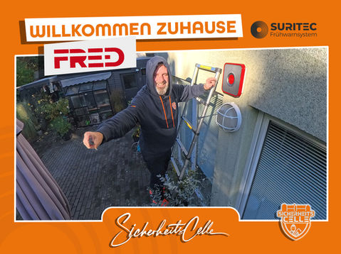 Björn zeigt den Außenmelder von FR.ED an einer Außenfassade in Celle