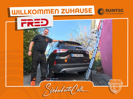 Björn Emanuelsson von SicherheitsCelle installiert ein FR.ED Frühwarnsystem an einer Hauswand. Unten steht das Firmenfahrzeug. Text: Willkommen Zuhause FR.ED. In Eschede in Niedersachsen