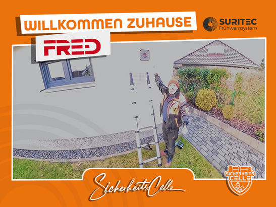 Björn Emanuelsson von SicherheitsCelle zeigt auf das montierte FR.ED Frühwarnsystem an einer Hauswand. Text: Willkommen Zuhause FR.ED, Logos von Suritec und SicherheitsCelle.