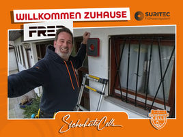 Björn Emanuelsson von SicherheitsCelle steht auf einer Leiter und montiert in Nienhagen einen Außenmelder von FR.ED