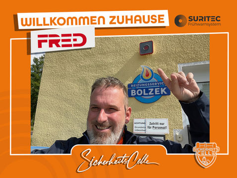 Björn Emanuelsson von SicherheitsCelle montiert ein FR.ED Frühwarnsystem bei Heizungsservice Bolzek. Text: Willkommen Zuhause FR.ED, Logos von Suritec und SicherheitsCelle.