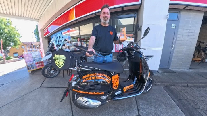 Björn Emanuelsson mit Vespa Roller und SicherheitsCheck Flyer bei der Esso Staion Celle