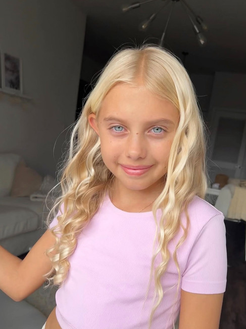 A blond girl with curly hair after using Kitsch heatless curls