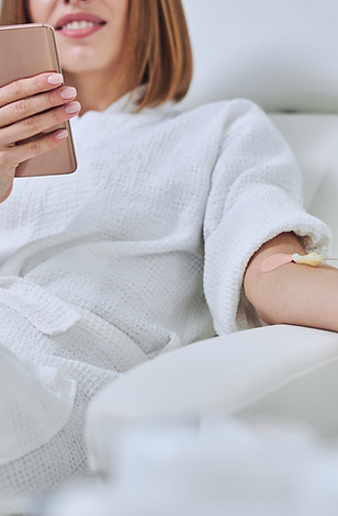 Beautiful Caucasian woman sitting in armchair during medicine procedure in spa salon_edite