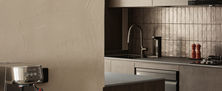 Dark Japandi kitchen interior with dark vertical tile backsplash matte grey cabinetry and warm strip lighting.