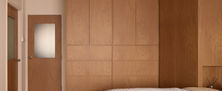 Mid-century Modern interior featuring seamless full-height wood grain cabinetry and matching timber doors.