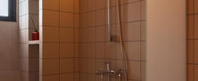 Compact Mid-century bathroom featuring square cream wall tiles, stainless steel shower fixtures, and a recessed storage niche.
