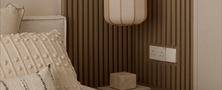 Cozy Light Resort Japandi bedroom bedside corner featuring a light wood slatted wall panel paper lantern pendant light and neutral bedding.