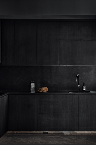 Modern luxury kitchen with black marble backsplash, black countertops, dark wood cabinetry, and sleek contemporary finishes