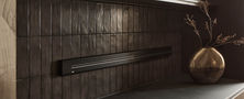 Minimalist Dark Japandi kitchen wall featuring a floating metal shelf with warm LED lighting and dark vertical tiles.