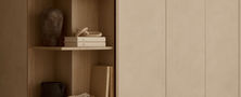 Custom light beige joinery with an integrated curved corner display shelf displaying ceramic decor in a Light Resort Japandi layout.