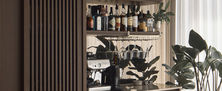 Bespoke dark timber home bar display unit with built-in wine fridge open shelves and potted houseplants near window.