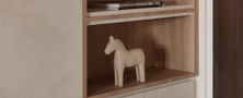 Modern minimalist entryway cabinet with light wood display recess, decorative figurine display, and seamless push-to-open doors by Intheory Design Singapore.