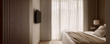 Master bedroom interior featuring clean neutral Japandi tones light wood flooring and soft light through sheer white curtains.
