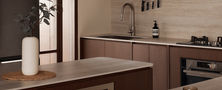 Dark wood kitchen island counter leading towards prep zone and custom upper joinery in a Singapore interior.