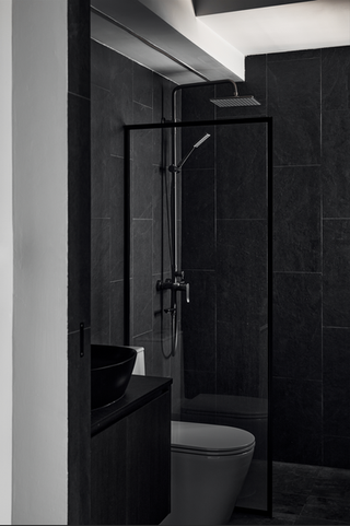 Dramatic black luxury bathroom interior with stone shower, cozy lighting, and contemporary sophisticated design