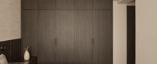 Minimalist Dark Japandi master bedroom wardrobe featuring full height dark charcoal timber cabinet doors.