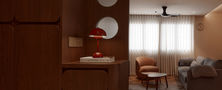 Entryway divider screen with round geometric cutouts opening into a sunlit living room with armchairs.