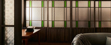 Modern Oriental living room featuring dark timber sliding doors with textured and green stained glass panels by Intheory Design Singapore.
