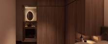 Modern Ryokan master suite showing full-height dark wood wardrobes and a glowing view into the en-suite washroom.