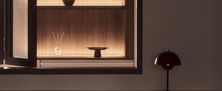 Close up view of custom illuminated dark timber shelf alcove displaying decor pieces in a luxury interior.