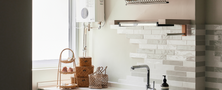 Charming kitchen yard area featuring a white ceramic farmhouse sink, sage green fluted cabinets, and open wall shelves.